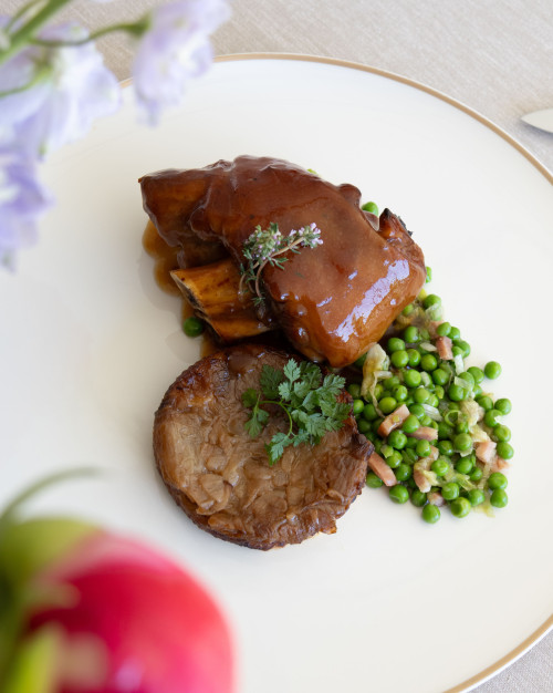 JARRET DE PORC BRAISE ET LAQUE, TARTE D’OIGNONS, PETITS POIS 